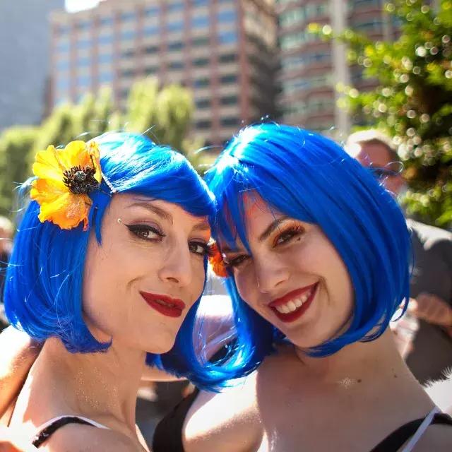 两名戴着蓝色假发的妇女参加贝博体彩app骄傲游行.
